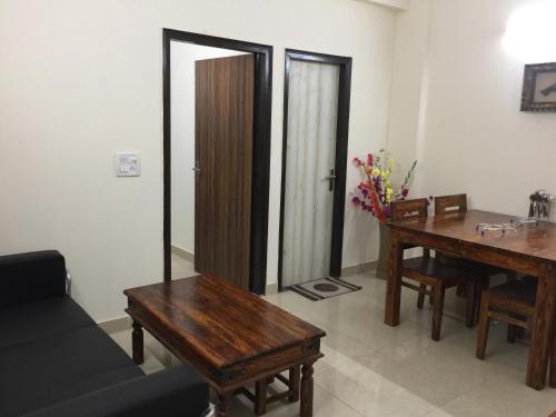 a living room with a couch and a table and a mirror at The Raveesh E24 - 2BHK Serviced Apartment in New Delhi
