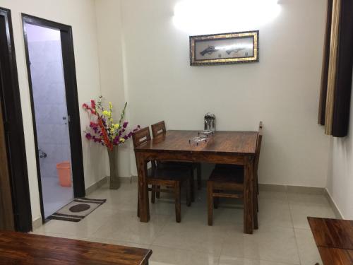 a dining room with a wooden table and chairs at The Raveesh E24 - 2BHK Serviced Apartment in New Delhi