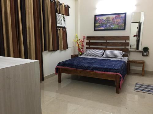 a bedroom with a bed with a blue comforter at The Raveesh E24 - 2BHK Serviced Apartment in New Delhi