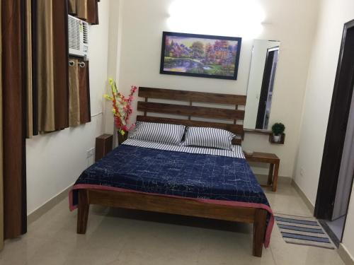 a bedroom with a bed with a blue comforter at The Raveesh E24 - 2BHK Serviced Apartment in New Delhi