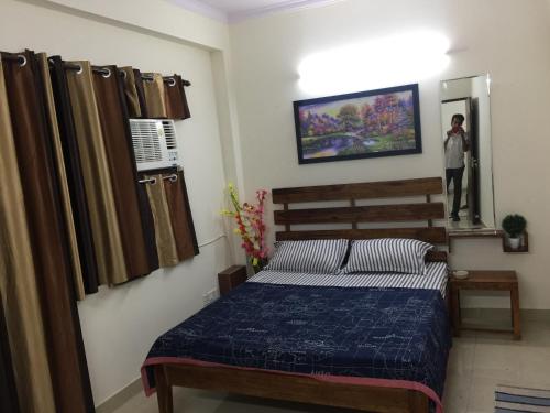 a bedroom with a bed and a person in a mirror at The Raveesh E24 - 2BHK Serviced Apartment in New Delhi