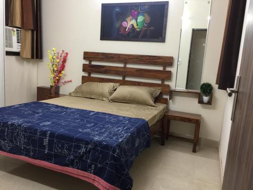 a bedroom with a bed with a blue comforter at The Raveesh E24 - 2BHK Serviced Apartment in New Delhi