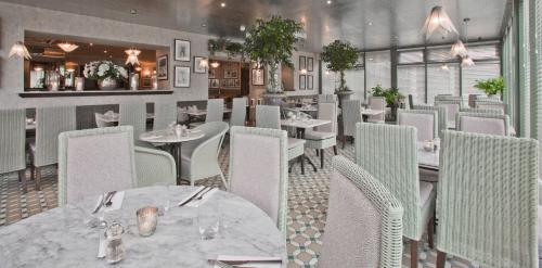 a dining room with tables and chairs in a restaurant at The Cults Hotel in Aberdeen