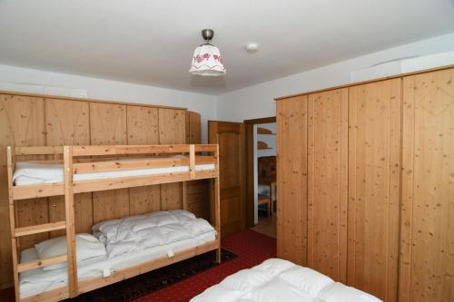 Ce lit se trouve dans un dortoir doté de 2 lits superposés et de murs en bois. dans l'établissement Happy Stay Apartment, à Bad Mitterndorf