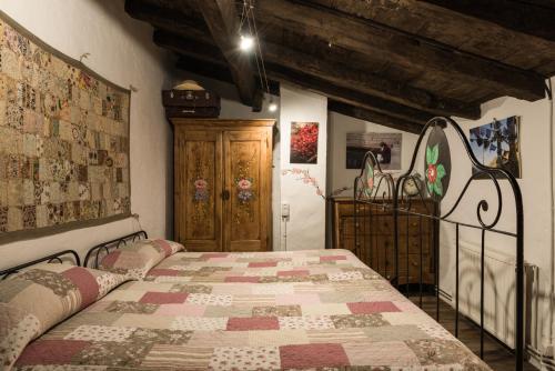 1 dormitorio con 1 cama con edredón en Casa Rural El Reixac en Sant Joan de les Abadesses