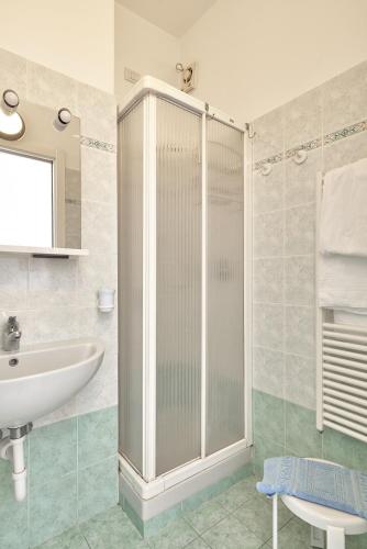 a bathroom with a glass shower and a sink at Albergo Natalina in Finale Ligure