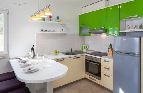 a kitchen with green cabinets and a white counter top at Relax Makarska in Makarska
