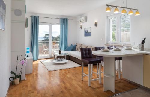 uma cozinha e sala de estar com uma mesa e um sofá em Relax Makarska em Makarska