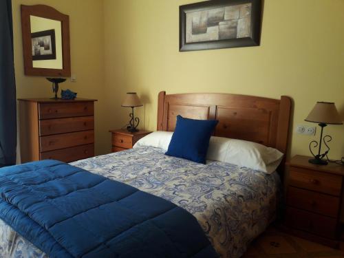 Un dormitorio con una cama con un edredón azul. en Apartamentos Vista La Maroma, en Viñuela
