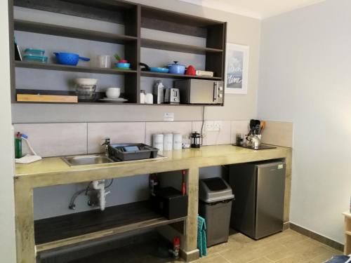 a kitchen with a wooden counter with a sink at Sea Wind Self Catering Cottages in Swakopmund