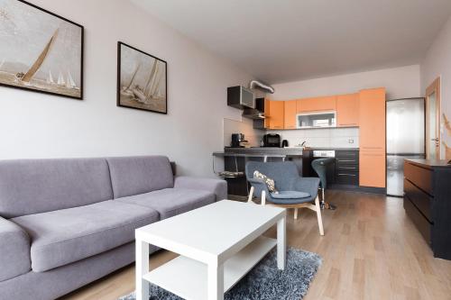 a living room with a couch and a table and a kitchen at The SUNNY PRAGUE APPARTMENT&Garage in Prague