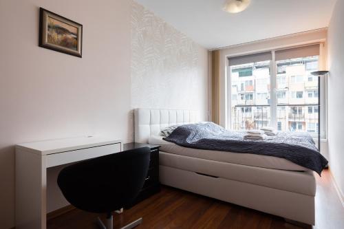 1 dormitorio con cama, escritorio y ventana en The SUNNY PRAGUE APPARTMENT&Garage en Praga