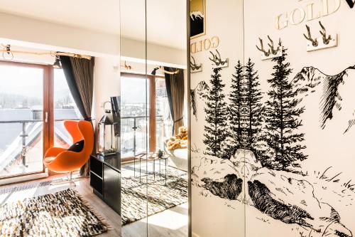 a living room with a wall mural of a mountain at Apartament Gold View in Zakopane