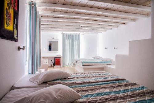 two beds in a room with white walls at Paradise Beach Resort in Paradise Beach