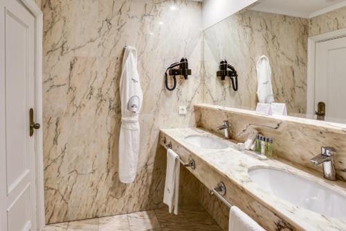 
a bathroom with two sinks and a mirror at Sercotel Hotel Europa in San Sebastián
