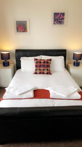 a bed with white sheets and pillows and two lamps at The Star Inn in Nottingham
