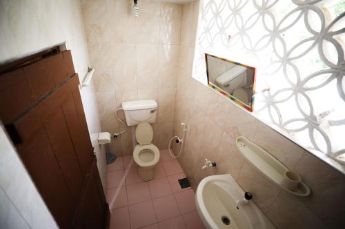 a small bathroom with a toilet and a sink at Tony's Garden House Back Packers inn in Jaffna