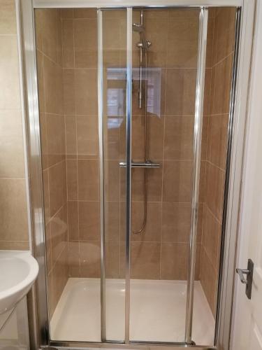 a shower with a glass door in a bathroom at Binswood Garden Apartment in Leamington Spa