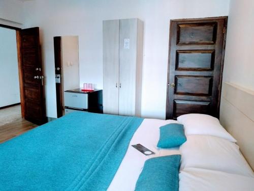 a bedroom with a bed with a cell phone on it at Santa Alejandría Hotel in Cartagena de Indias