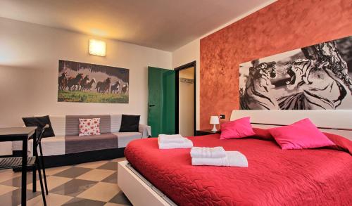 コモにあるCasa Aurora Self Catering Studio Como Vacanzeのベッドルーム(赤いベッド1台、ソファ付)