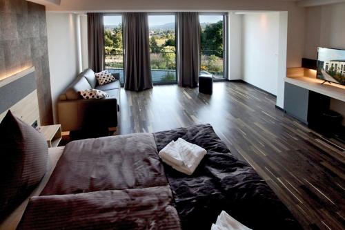 a large living room with a couch and a tv at Boutiquehotel Genusswerk Eifel in Körperich