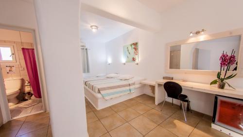 a bedroom with a bed and a desk and a mirror at Paradise Beach Resort in Paradise Beach