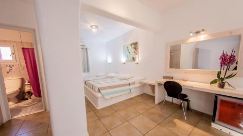 - une chambre avec un lit, un bureau et un miroir dans l'établissement Paradise Beach Resort, à Paradise Beach