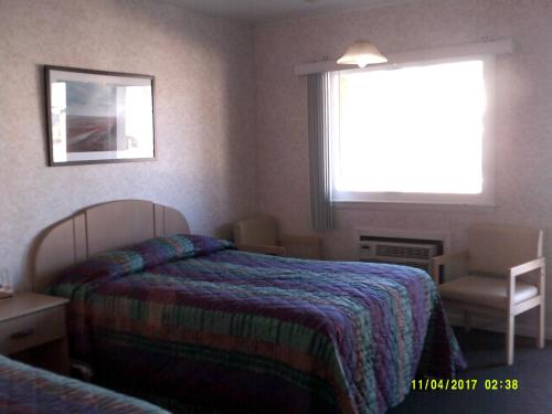 a hotel room with a bed and a window at Sea Esta Motel 1 in Dewey Beach