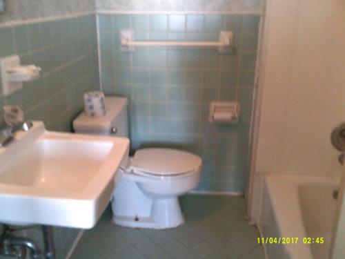 a bathroom with a toilet and a sink and a tub at Sea Esta Motel 1 in Dewey Beach