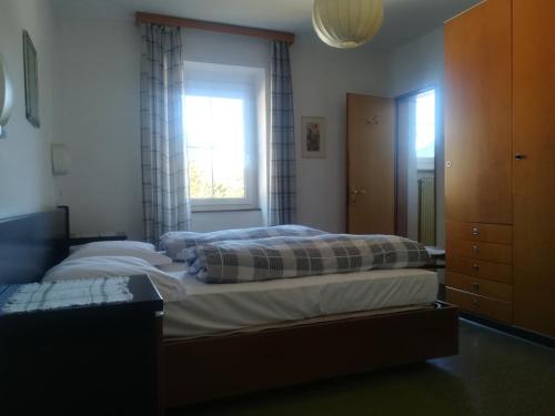 een slaapkamer met een groot bed en een raam bij Hotel Roen Ruffrè-Mendola in Mendola