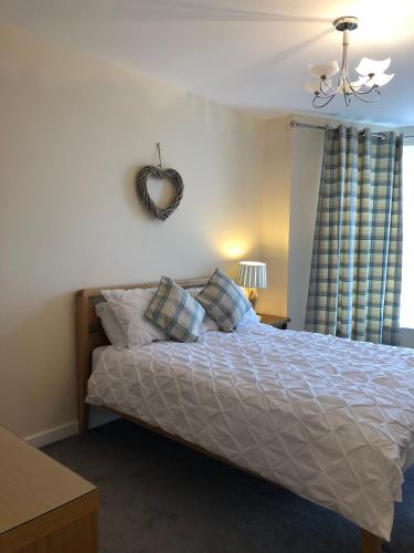 a bedroom with a bed with a heart mirror on the wall at Morecambe sea view apartment 203 in Morecambe
