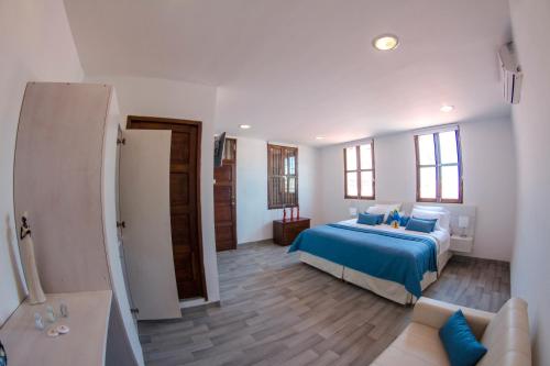 a bedroom with a blue bed and a couch at Santa Alejandría Hotel in Cartagena de Indias