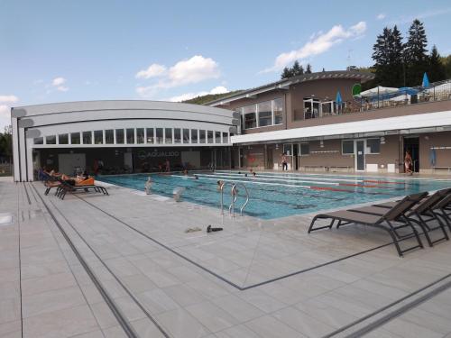 une grande piscine en face d'un bâtiment dans l'établissement Hotel Roen Ruffrè-Mendola, à Mendola