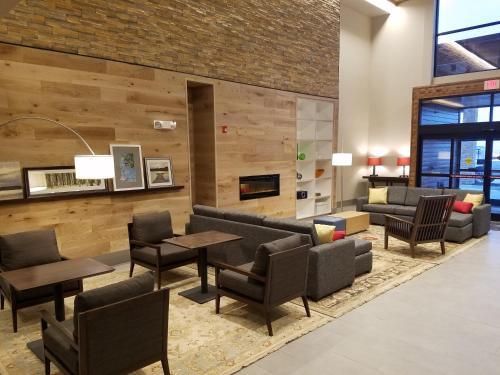 a lobby with couches and tables and chairs at Country Inn & Suites by Radisson, Lawrence, KS in Lawrence