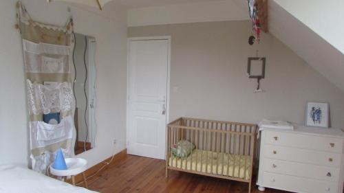 1 dormitorio con cuna y escalera en una habitación en Côté Prairie en Épagne-Épagnette