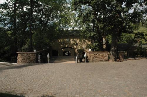a brick walkway in a park with a tree at SPA Hotel in Vorzelʼ
