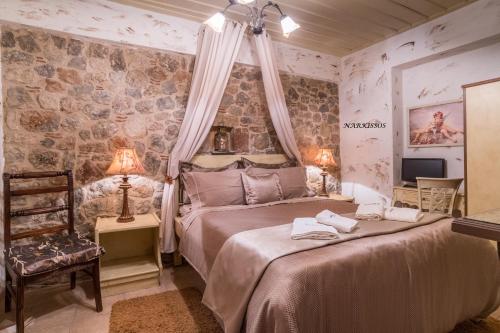a bedroom with a bed in a room with stone walls at Ampolis Guest House in Arachova