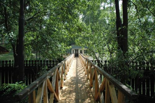 a wooden bridge in a park with a house on it at SPA Hotel in Vorzelʼ
