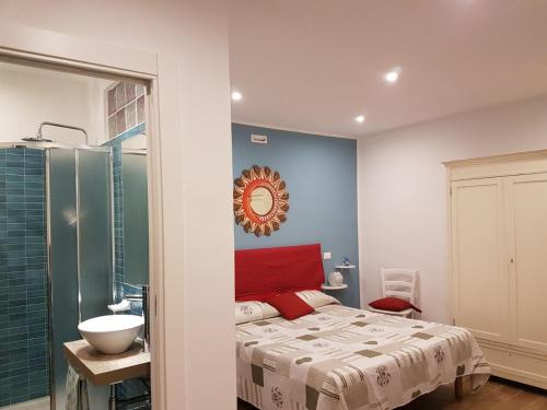 1 dormitorio con cama, lavabo y espejo en La Rosa dei Venti en Isola delle Femmine