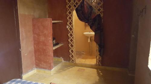 Habitación con pasillo con espejo y baño. en Secret du Sahara, en Merzouga