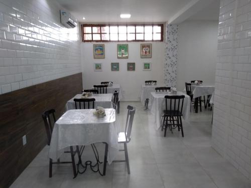 una sala da pranzo con tavoli e sedie con tovaglia bianca di Hotel Imperial a Palmeira dos Índios