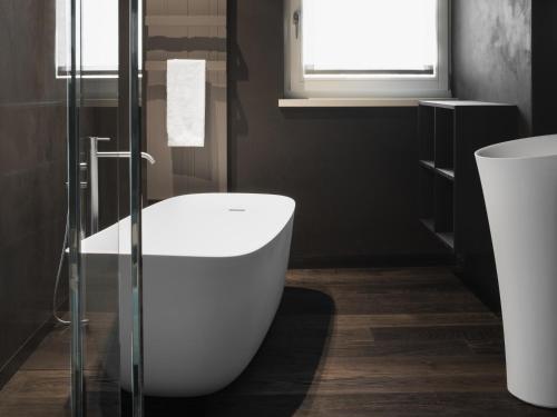 a bathroom with a white tub and a sink at Guesthouse Suiteseven in Merano