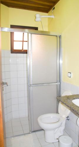 a bathroom with a toilet and a shower and a sink at Chalés Mariah in Ubatuba