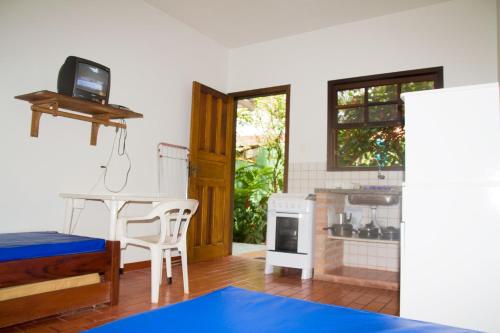 un soggiorno con tavolo e cucina di Chalés Mariah a Ubatuba