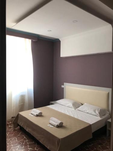 a bedroom with a bed with two towels on it at Hotel Paganini in Florence