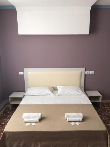 a bedroom with a bed with two towels on it at Hotel Paganini in Florence