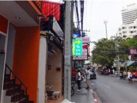 a building on the side of a street with people standing outside at Orchid Inn in Bangkok