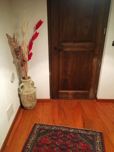 a vase sitting on the floor next to a door at La maison de vali in Aosta