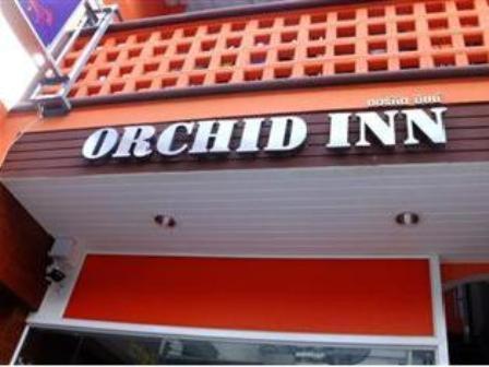 an old inn sign on the side of a building at Orchid Inn in Bangkok