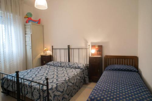 a bedroom with two beds and a window at Villetta Rossella Mancaversa in Marina di Mancaversa